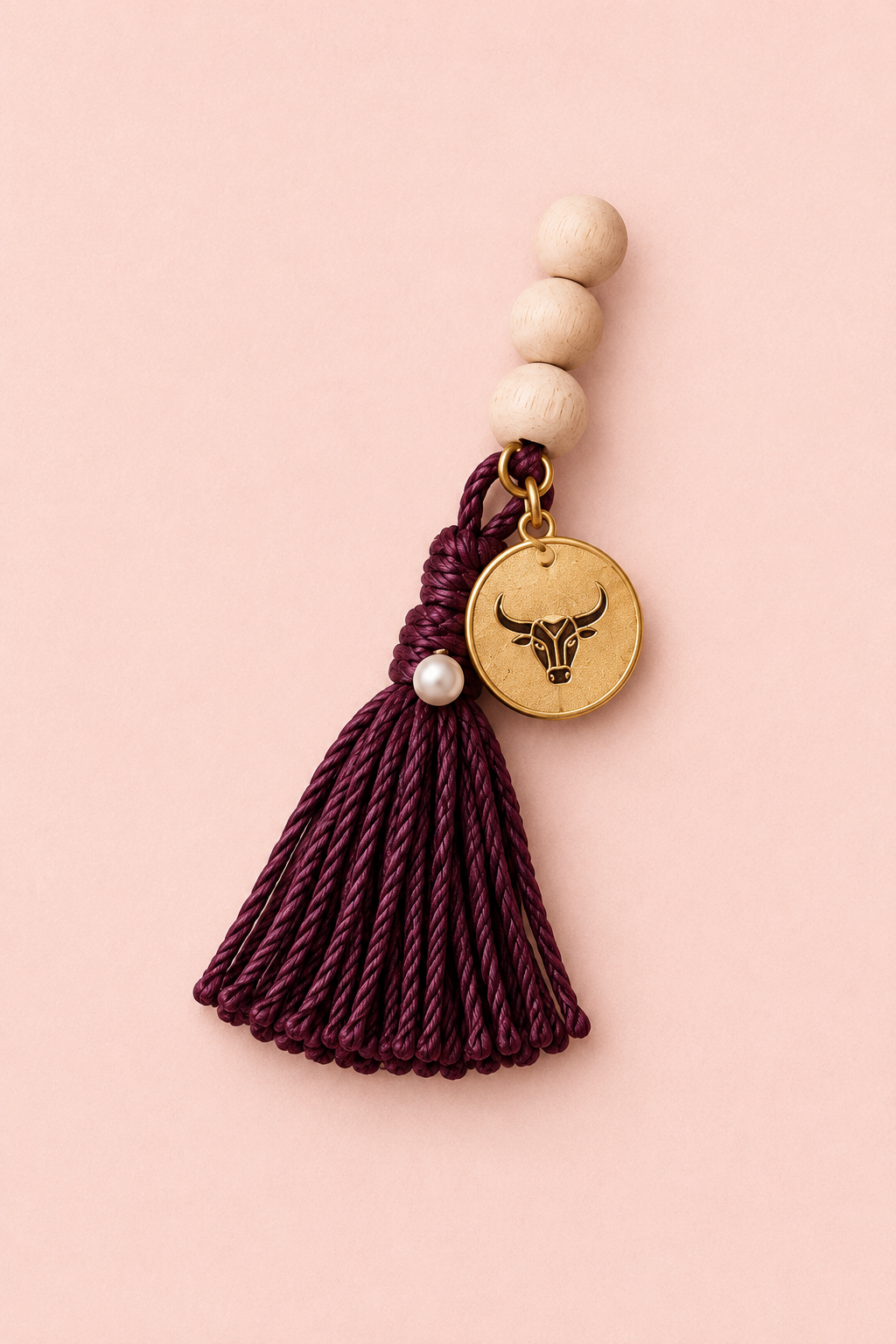 Création DIY avec pompon bordeaux, perles et médaillon doré